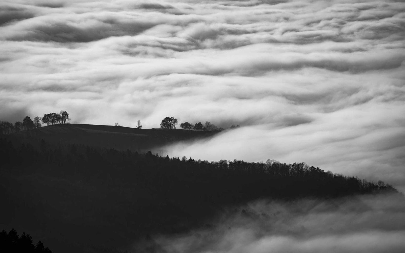 Fog rolling over dark hills